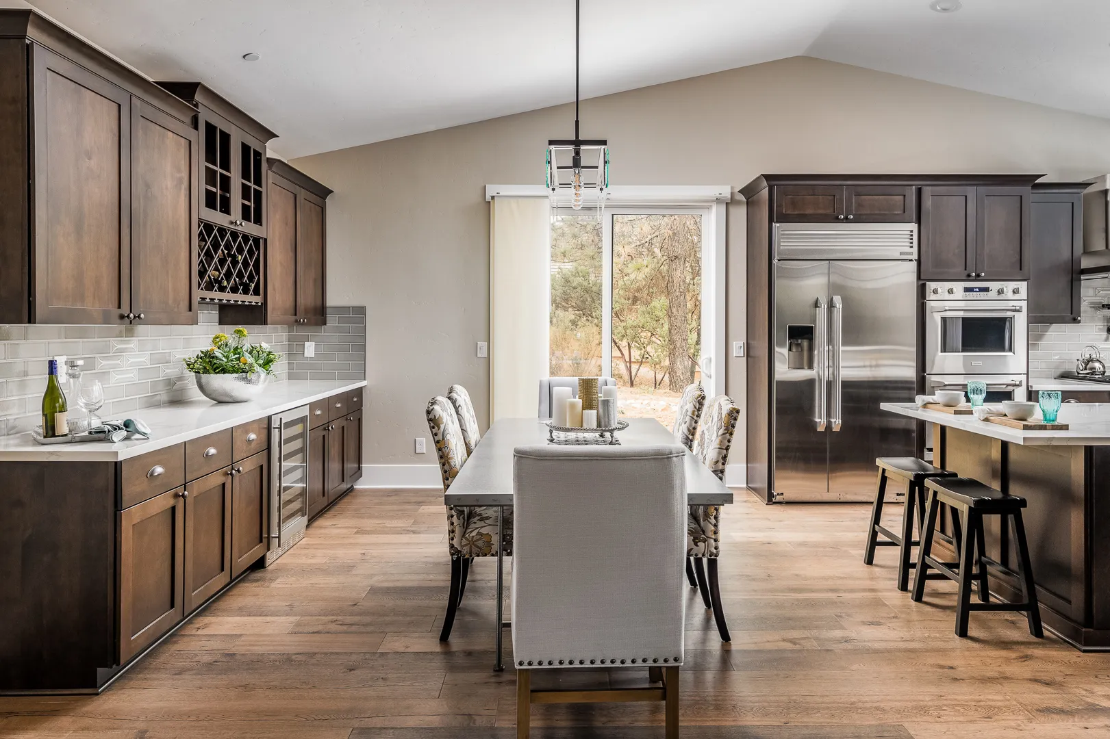 Dining area with buffet wall, wine cooler, and sliding glass door to the wooded backyard