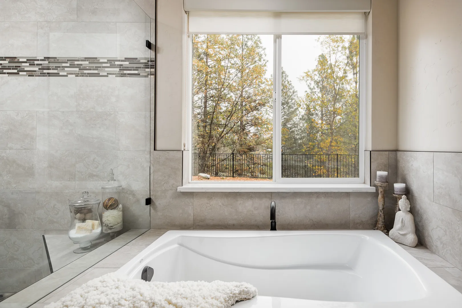 Soaking tub beneath a picture window overlooking autumn pines in Meadow Vista