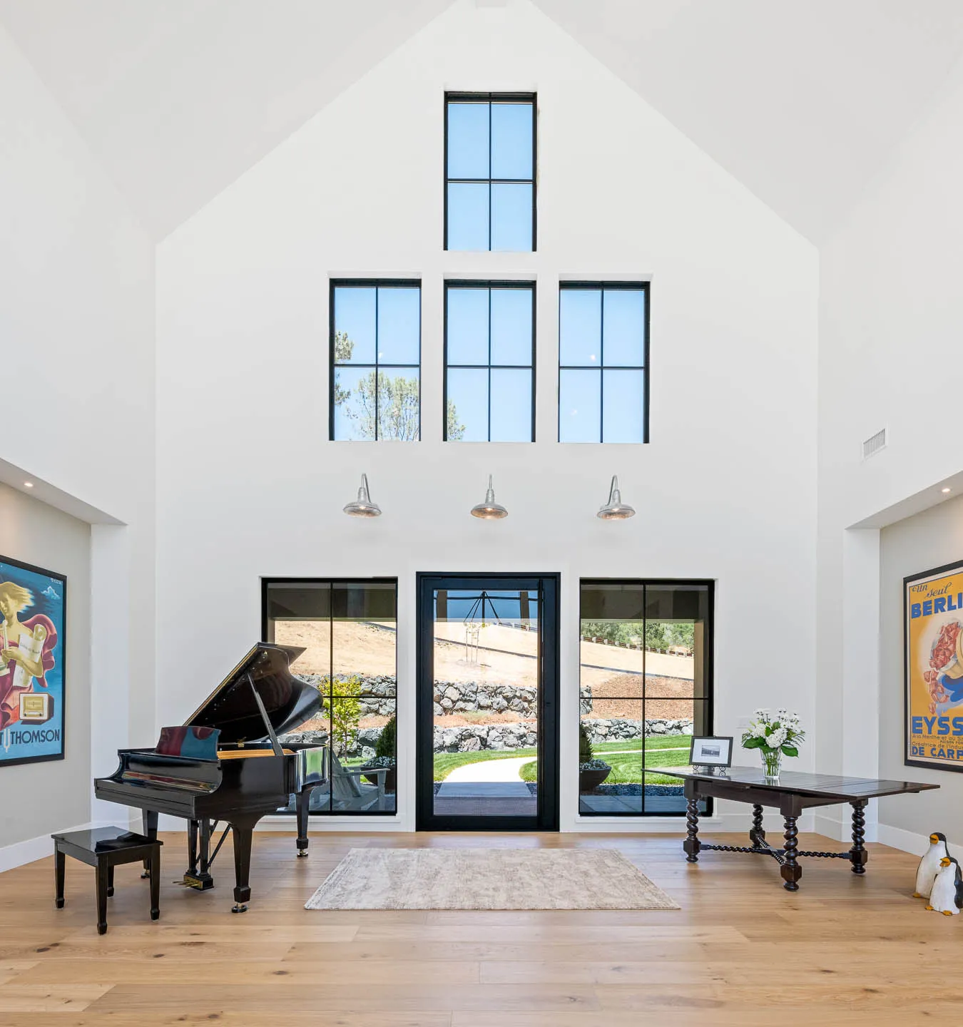 Soaring two-story foyer with glass entry door and grand piano in a Sherman custom home