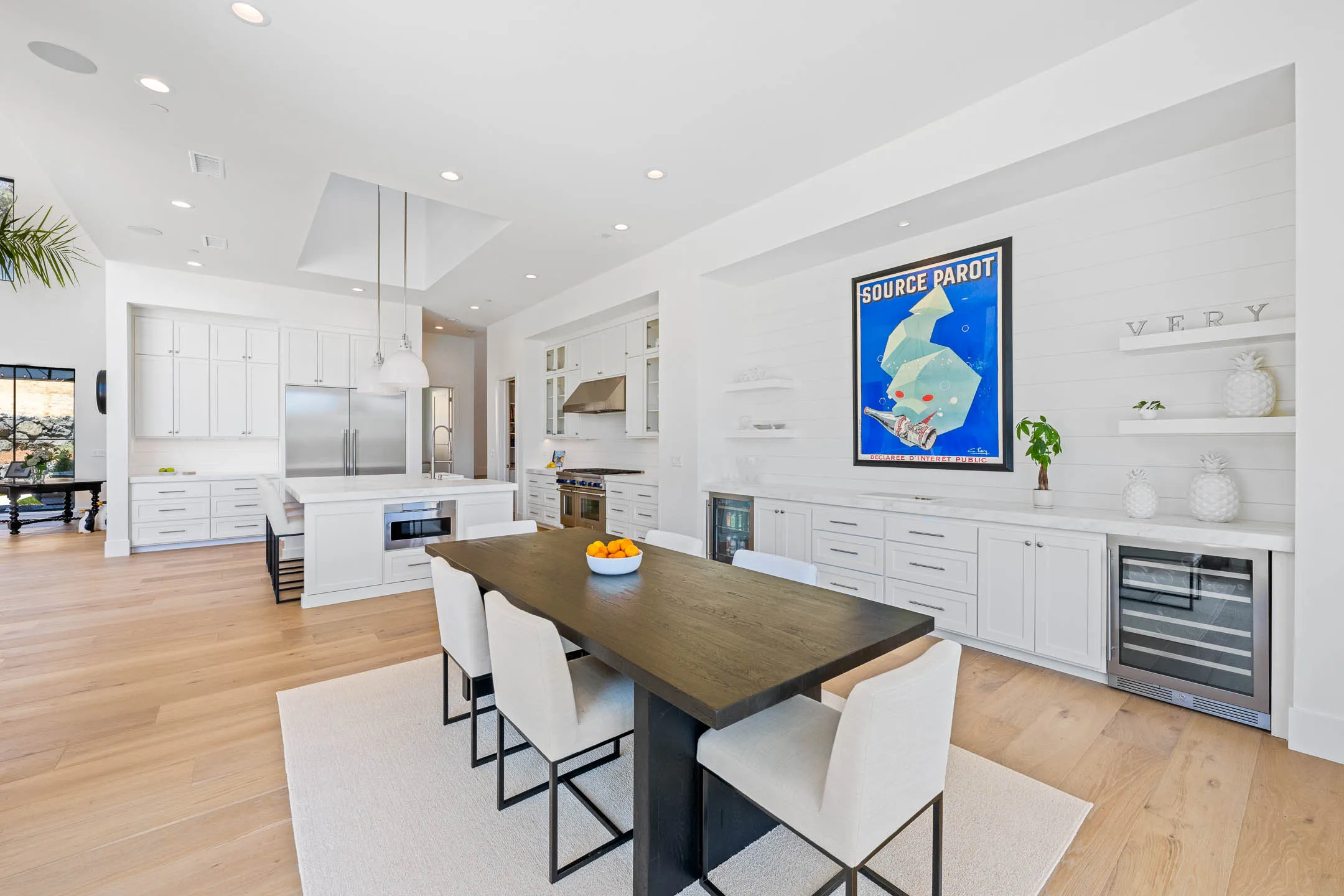 Casual dining area with dark oak table beside a built-in buffet and wine refrigerator