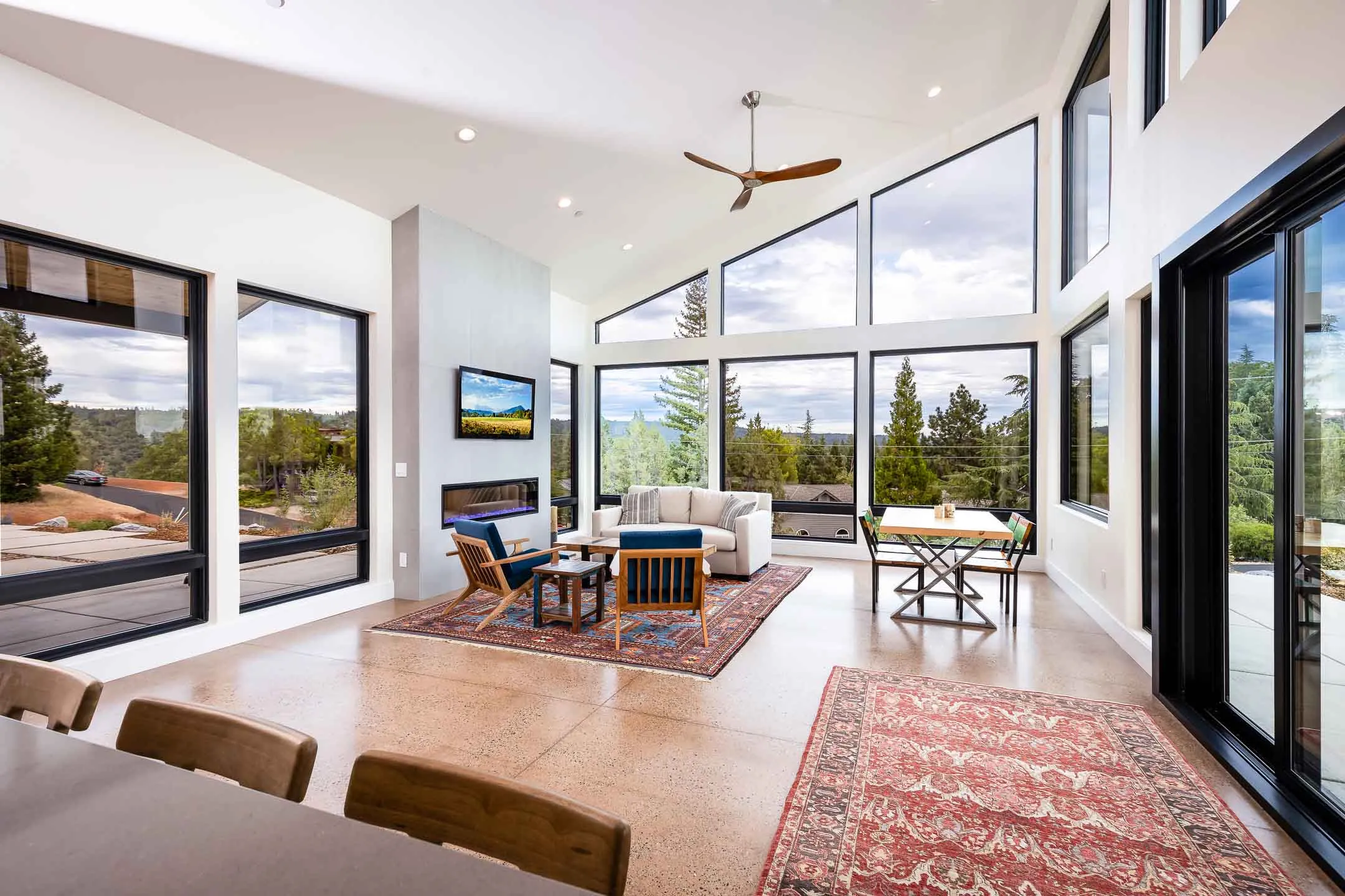 A vaulted great room with a linear fireplace and floor-to-ceiling windows in a Sherman home