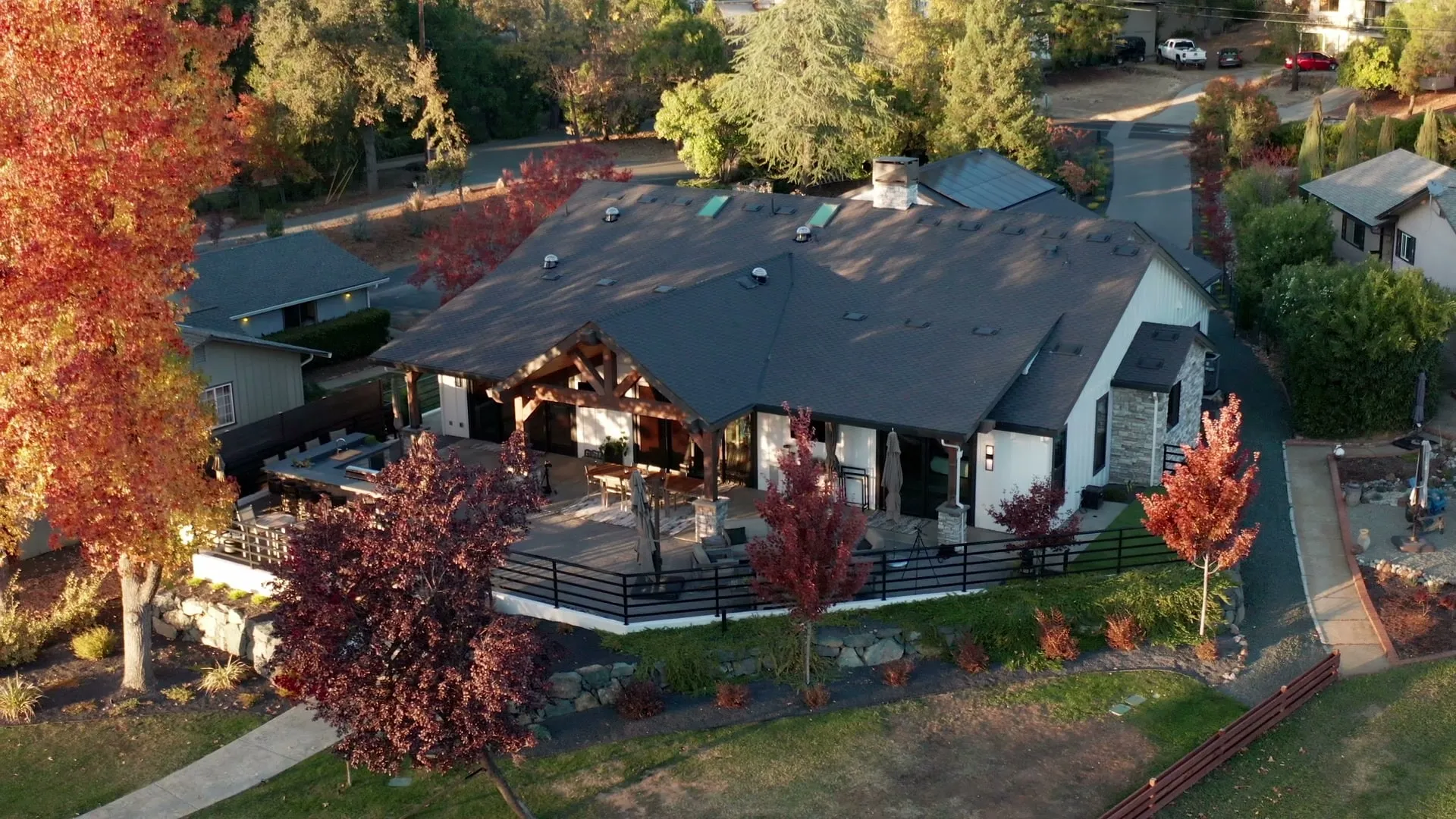 Aerial view of a lakefront custom home among fall color on Lake of the Pines