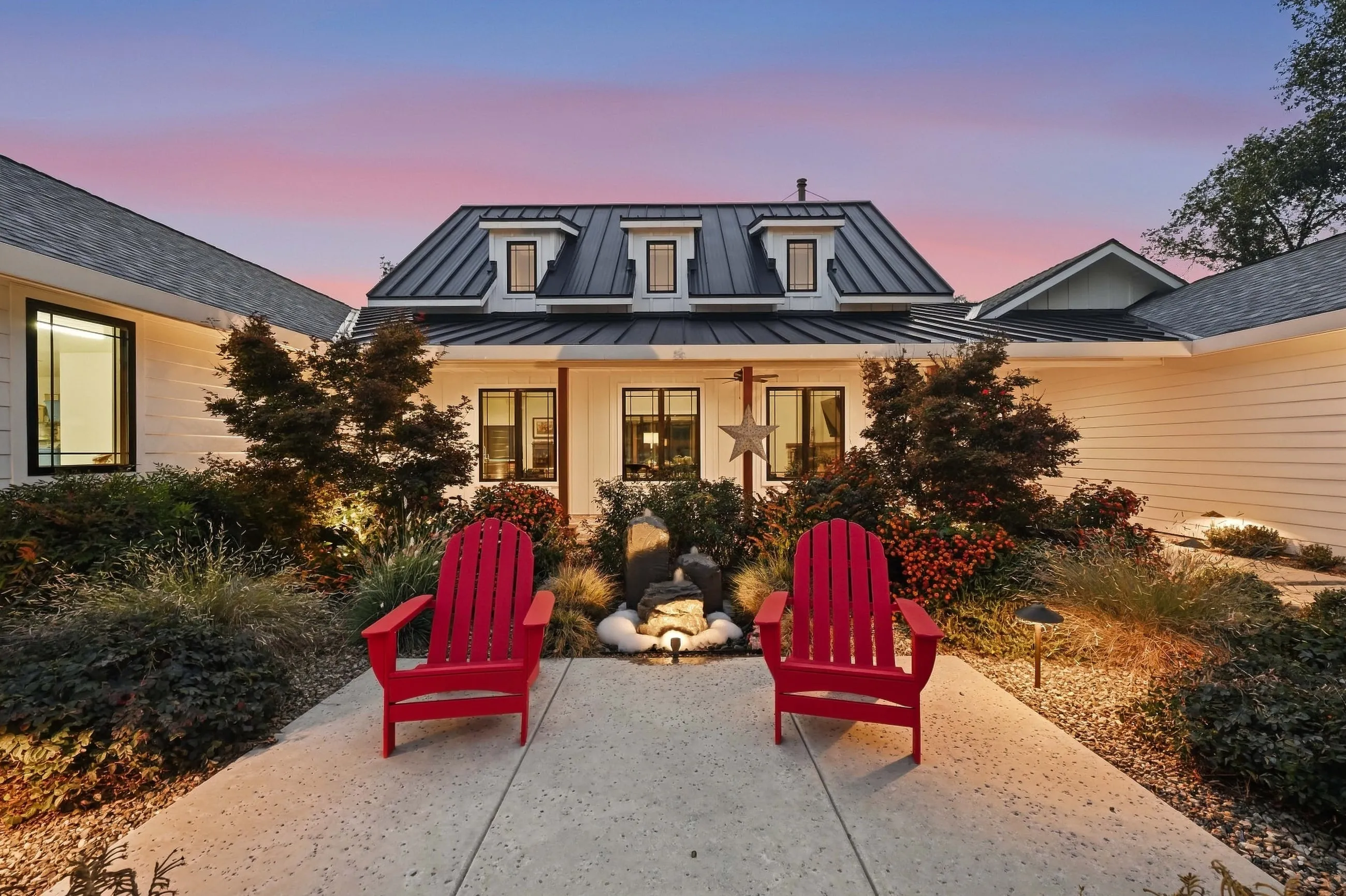 Entry courtyard at twilight with a pair of red Adirondack chairs
