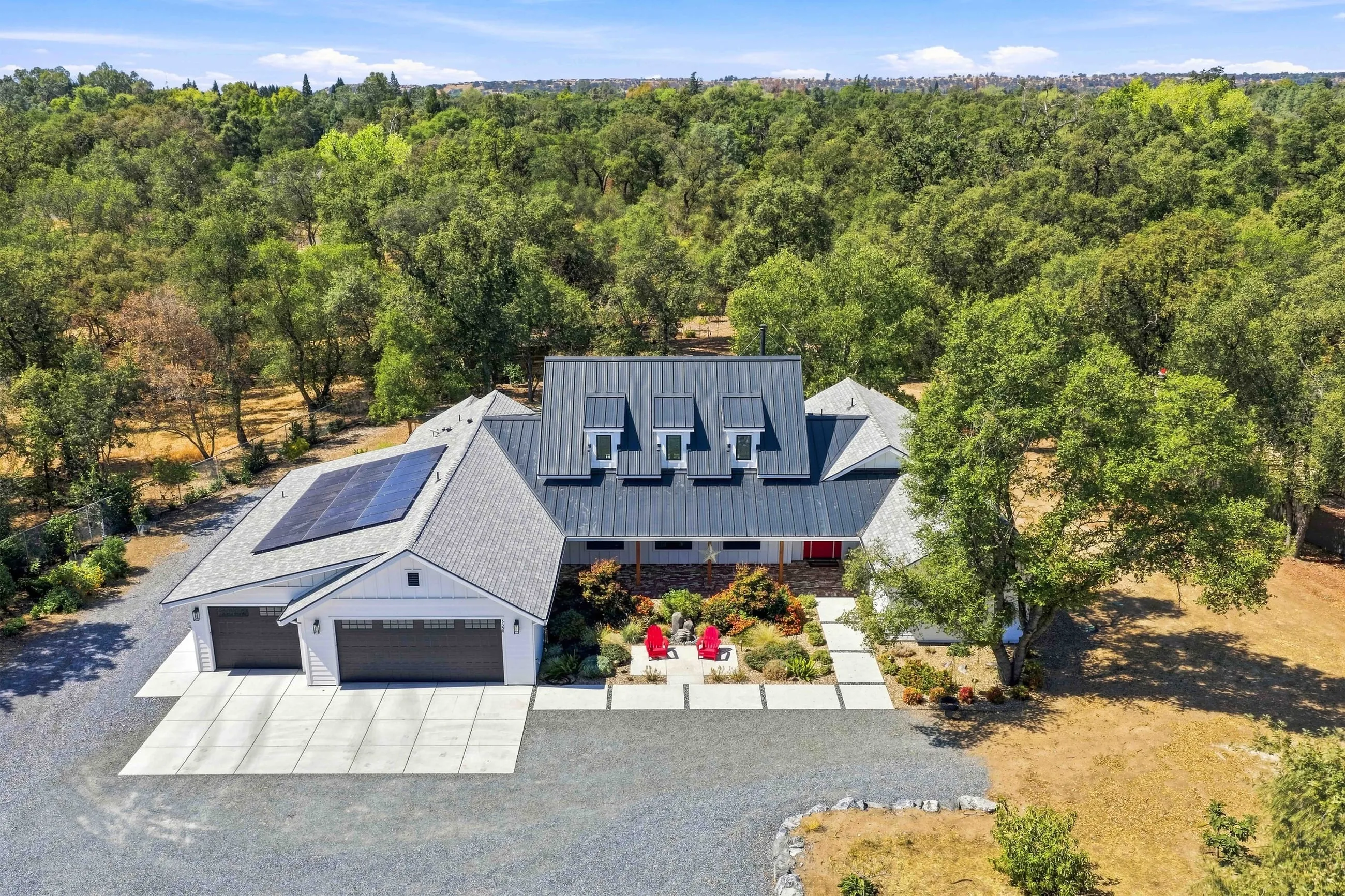 Drone view of the front with rooftop solar and gravel motor court