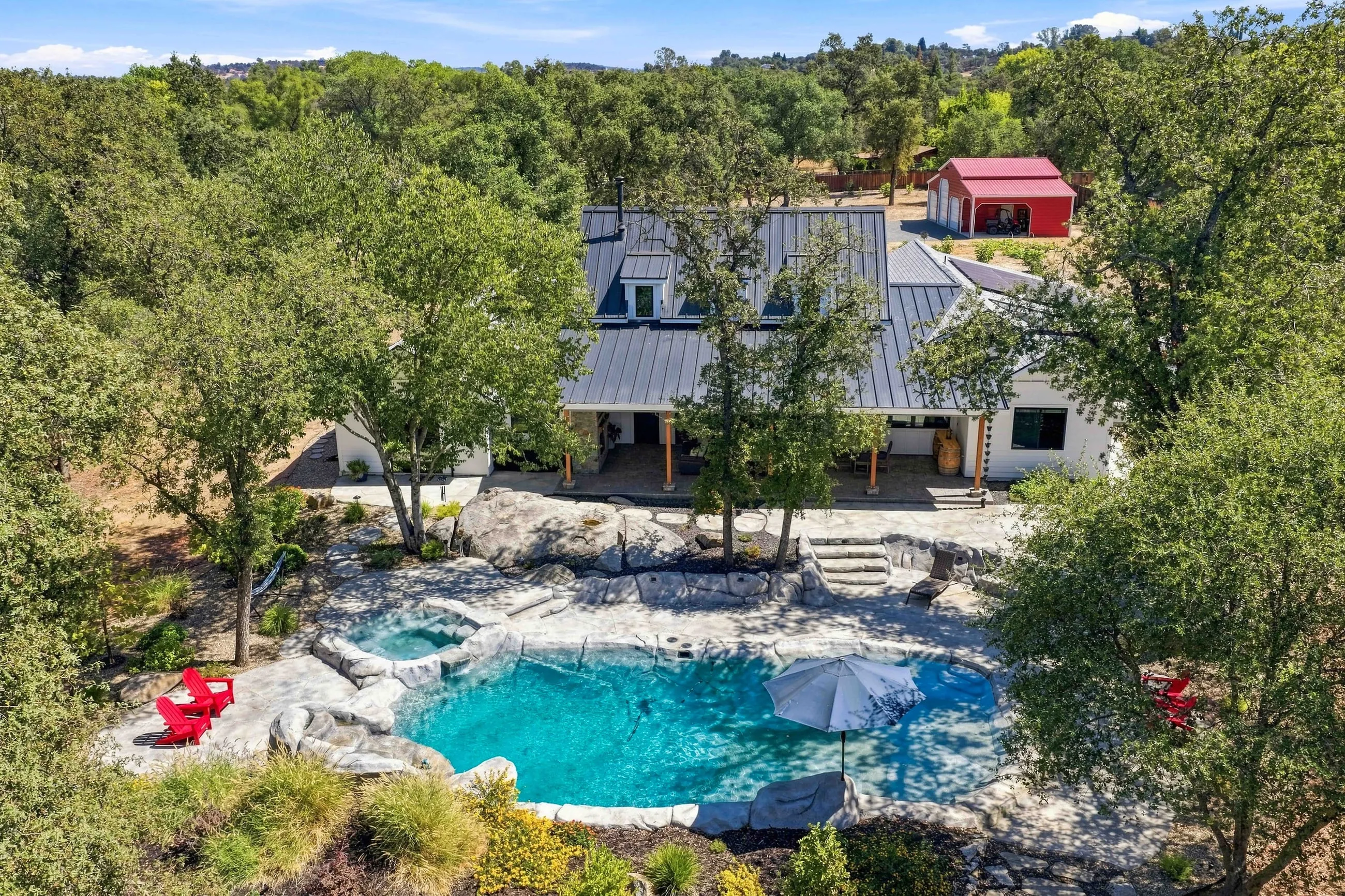 Aerial of the rear with lagoon-style pool and rock waterfall