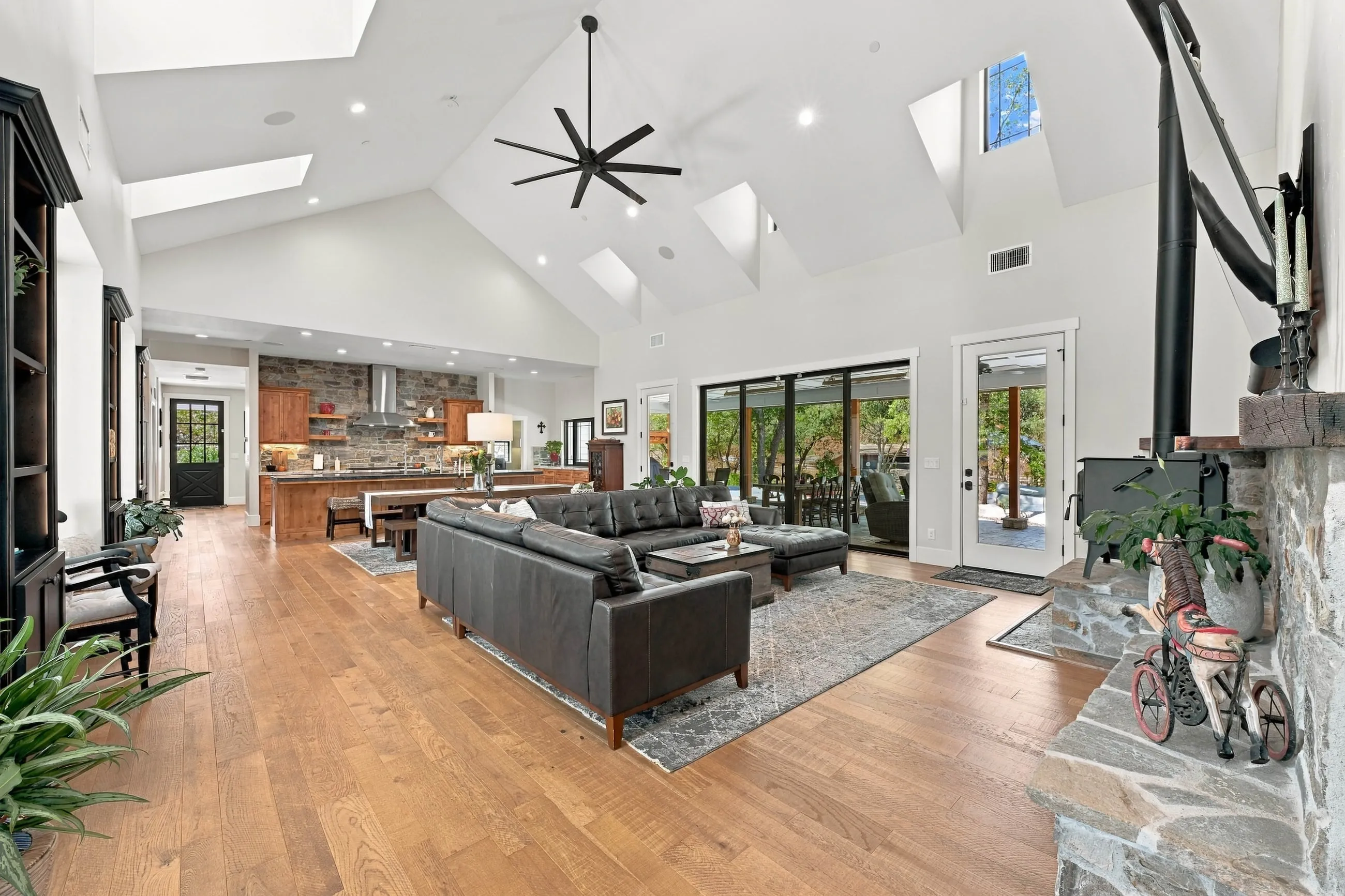 Vaulted great room with skylights, leather sectional, and open kitchen beyond