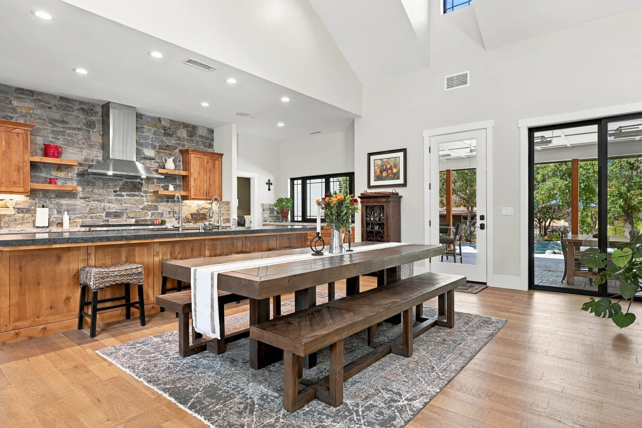 Dining and kitchen with knotty alder cabinets and a full-height stacked-stone range wall
