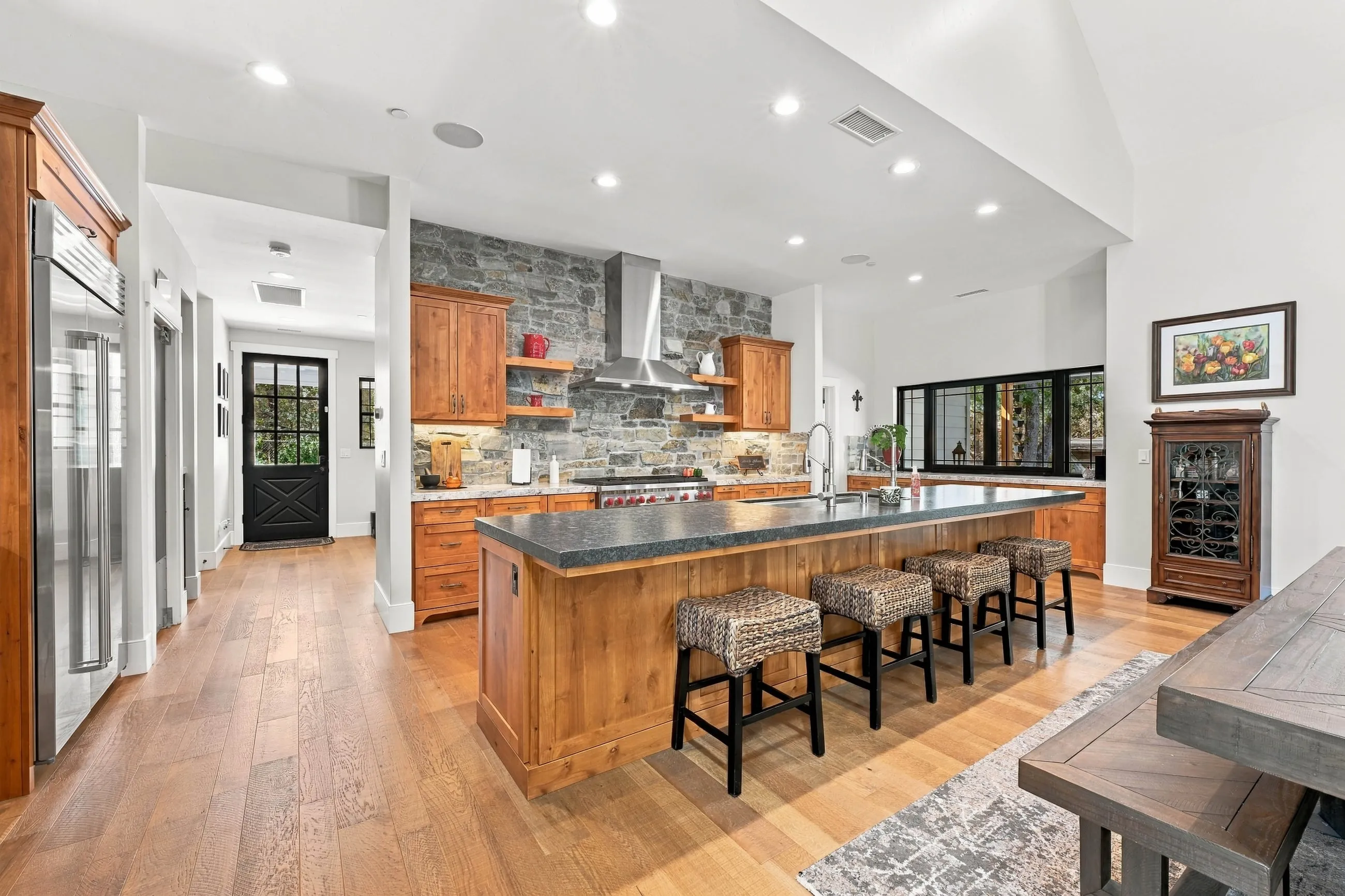 Kitchen island with woven stools and stainless appliances