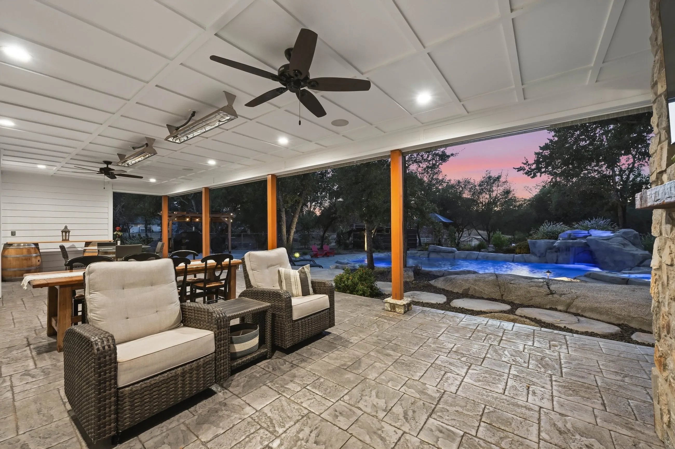 Porch lounge seating overlooking the lit lagoon pool