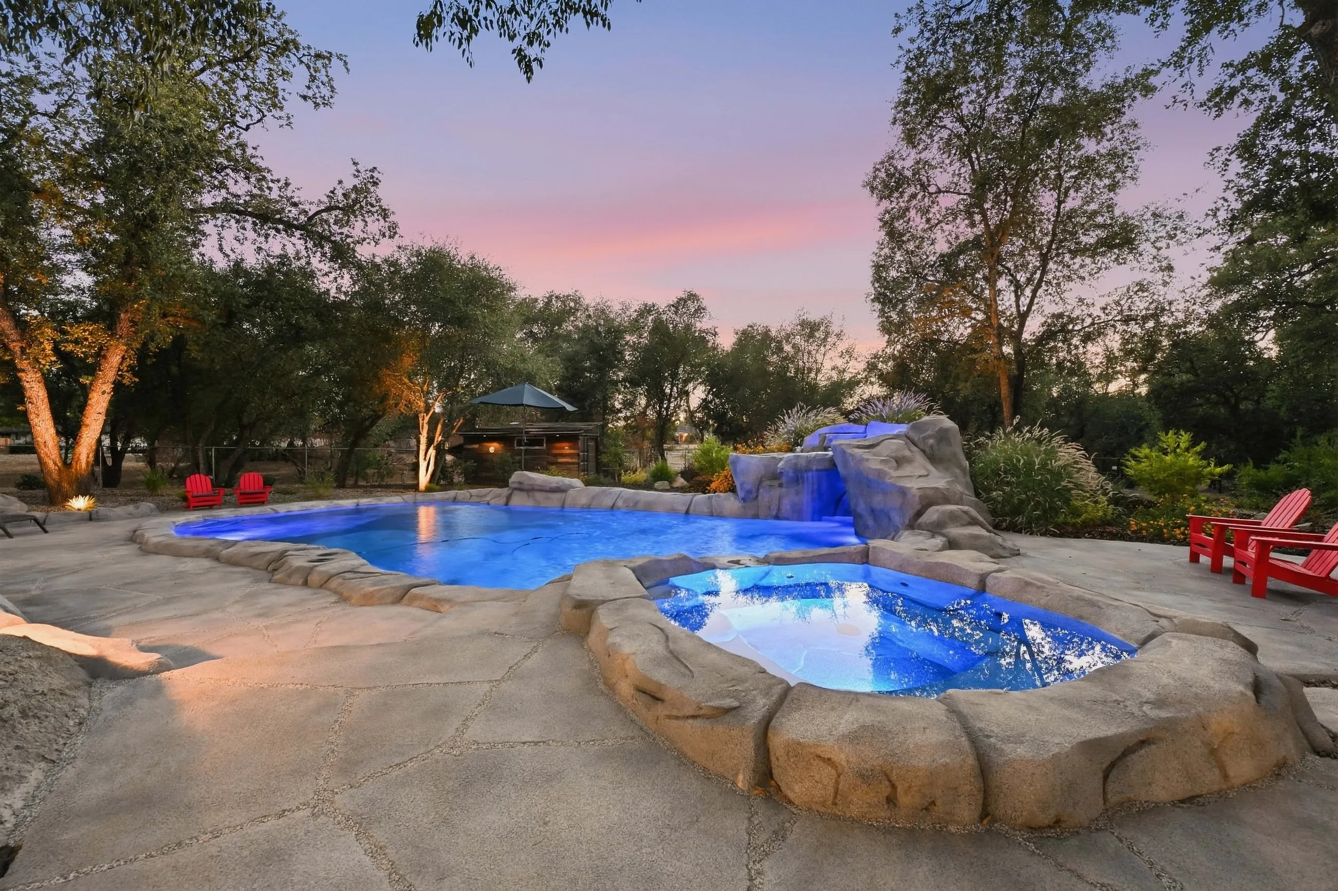 Rock-rimmed spa and pool at dusk