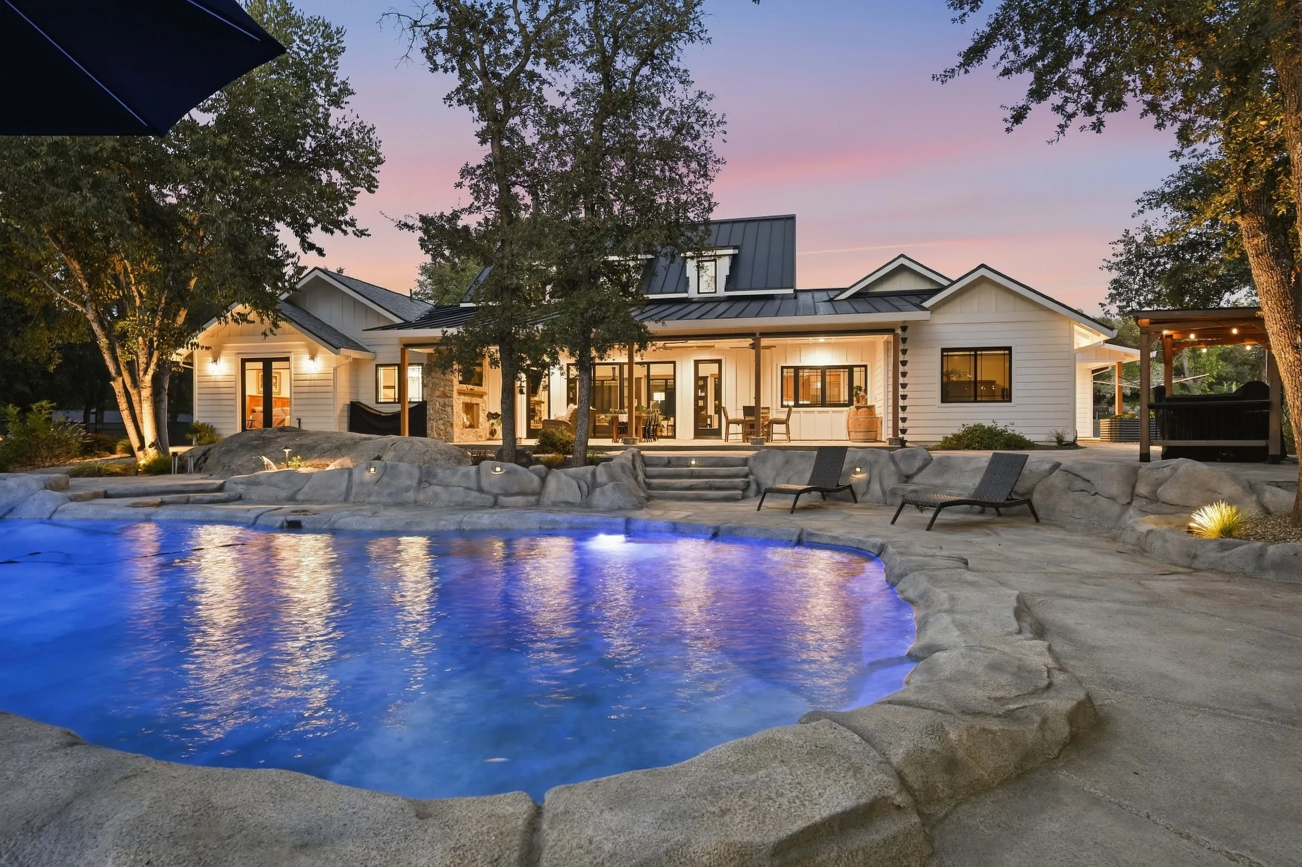 Rear of the farmhouse reflected in the pool at twilight
