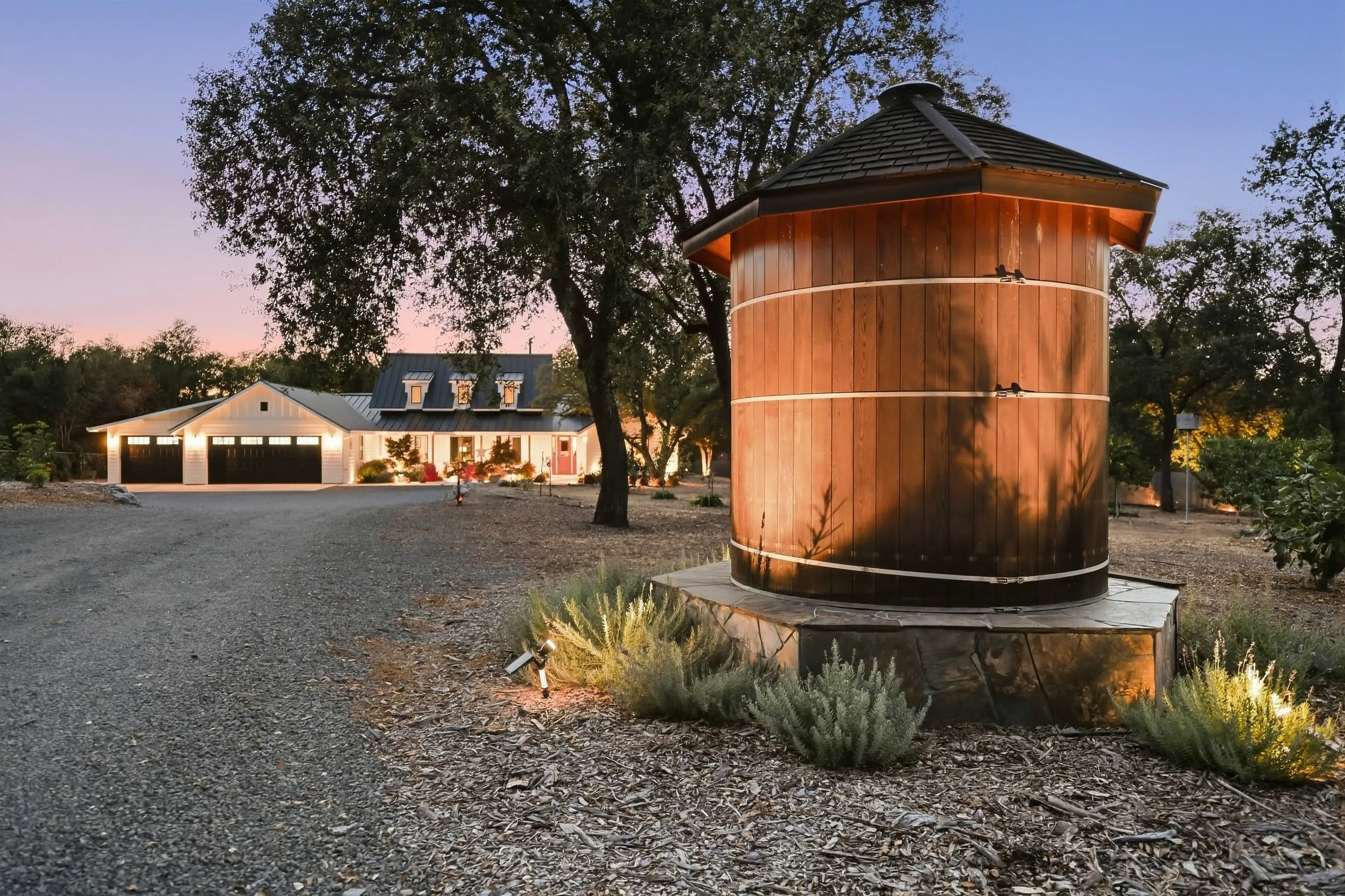 Decorative wooden water tank at the entry drive at dusk