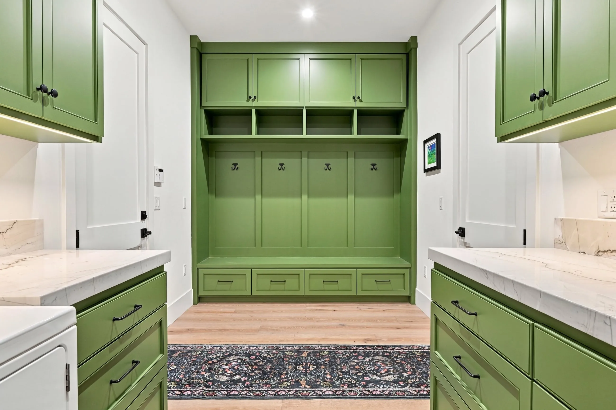 Mudroom with green built-in lockers, cubbies, and bench
