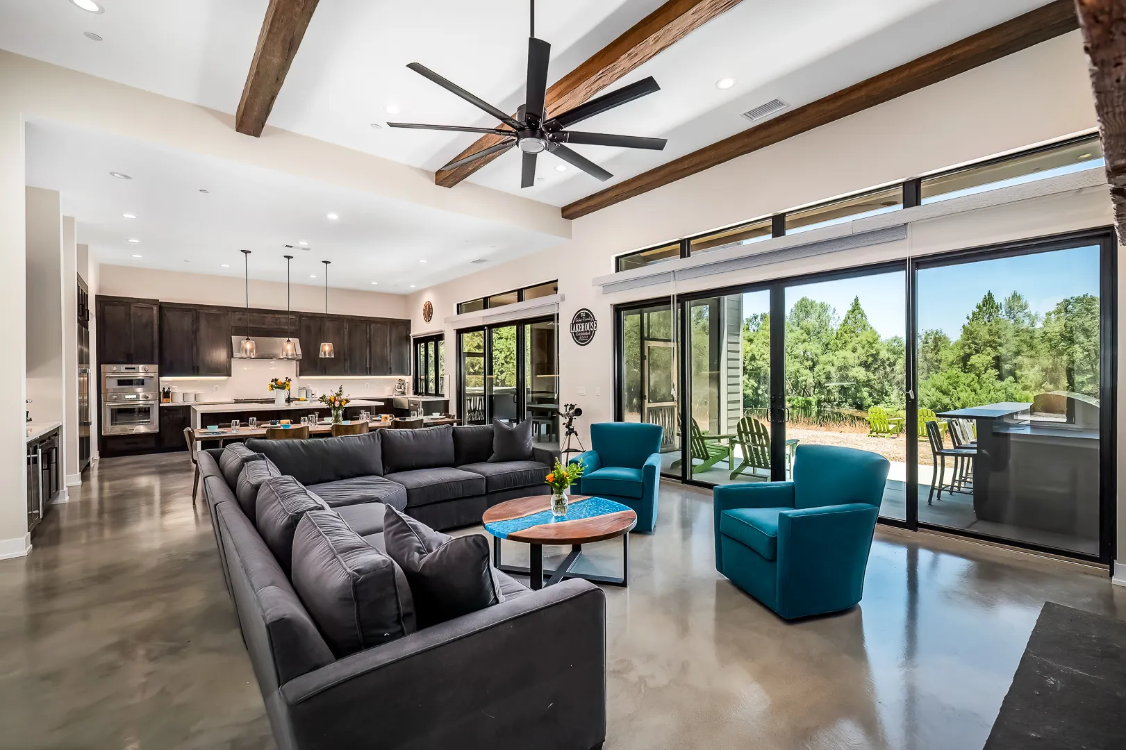 Open living area with polished concrete floors and sliding glass walls to the covered patio