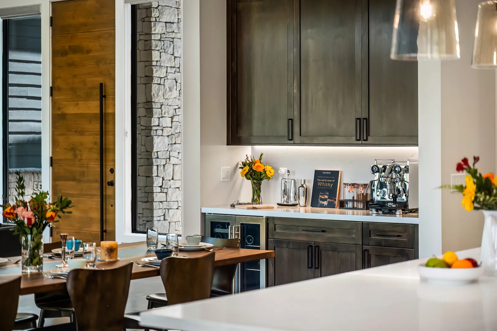 Butler's bar with espresso machine, beverage fridge, and under-cabinet lighting beside the dining area