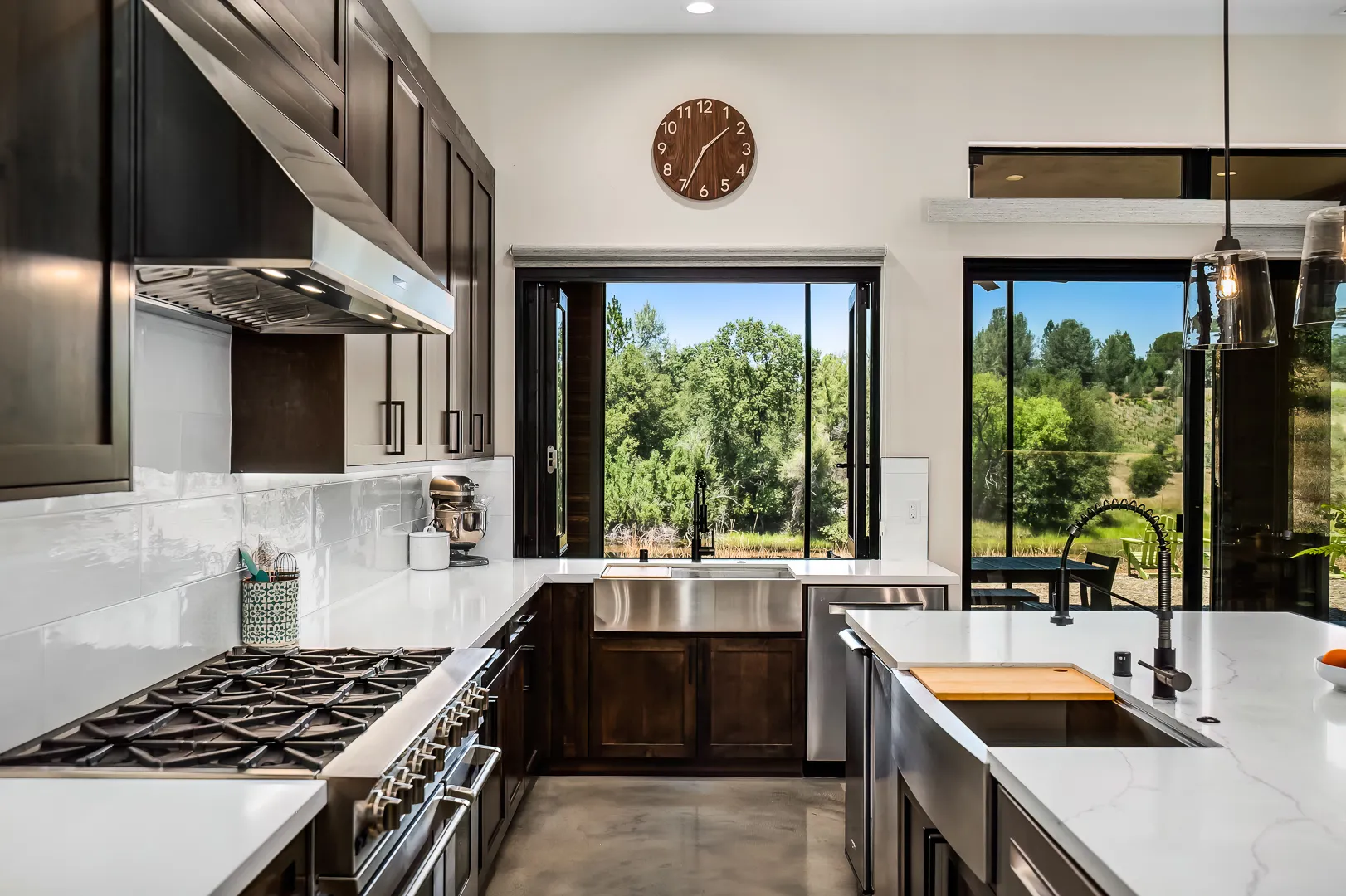 Kitchen with a professional range, stone hood surround, and knotty alder cabinets in a Sherman custom home
