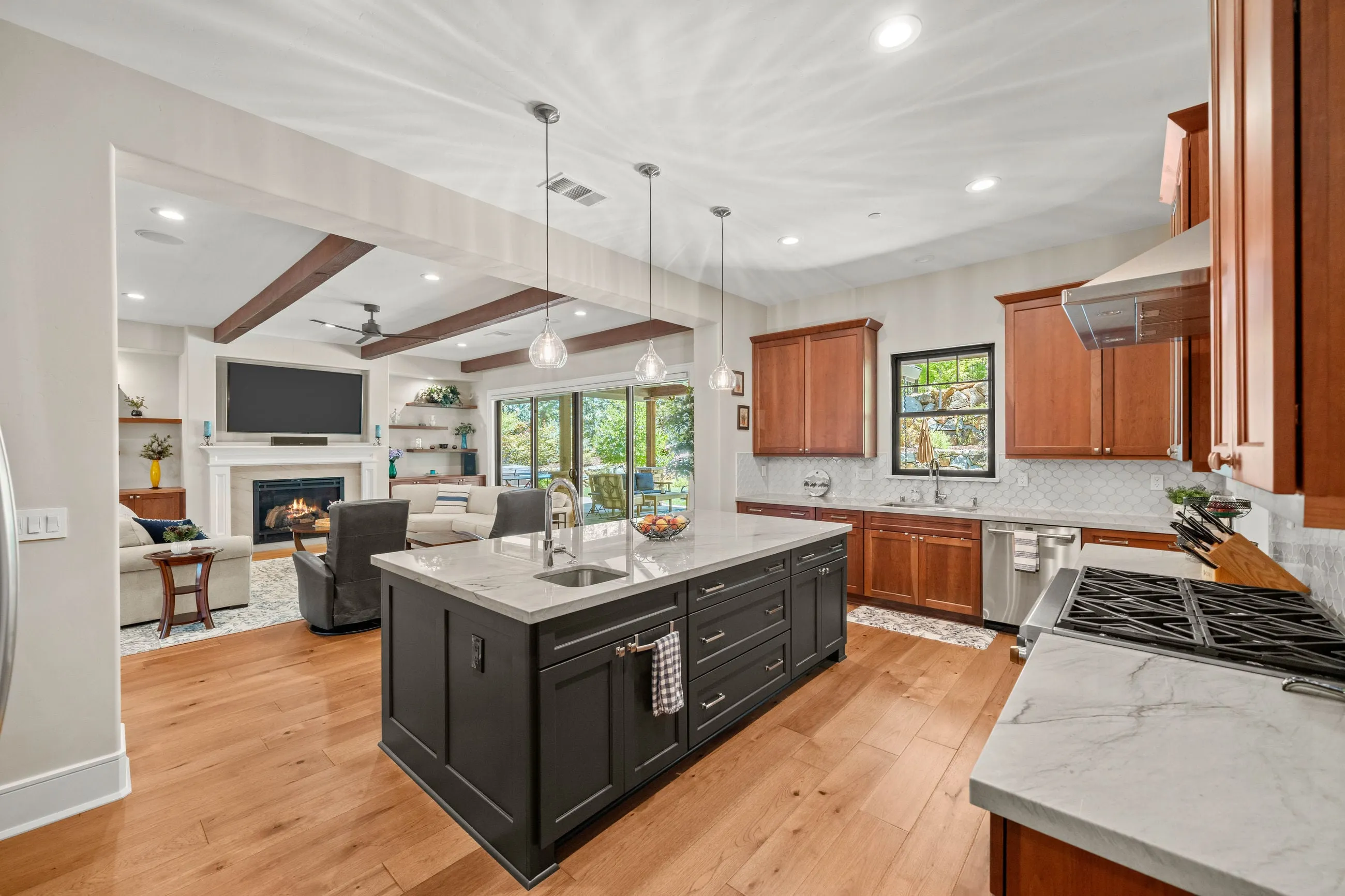 Kitchen island with prep sink looking toward the family room fireplace and patio sliders
