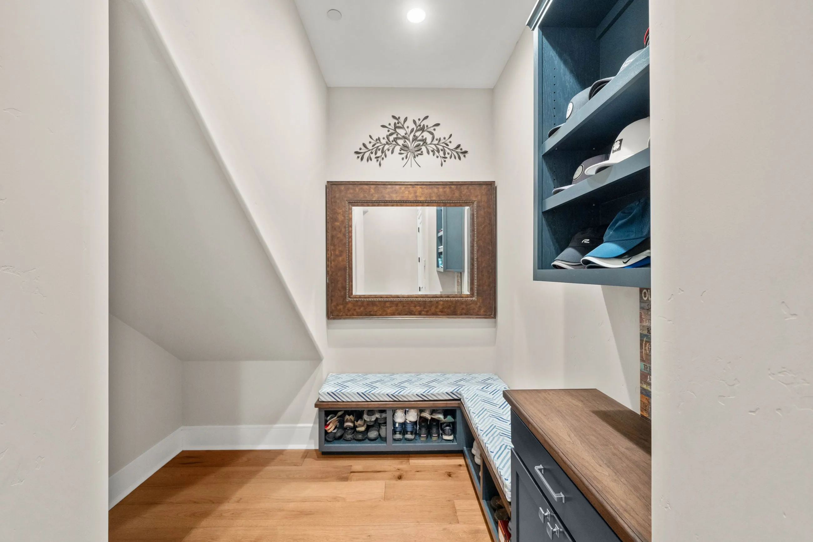 Mudroom nook with a cushioned bench, shoe cubbies, and navy built-in shelving