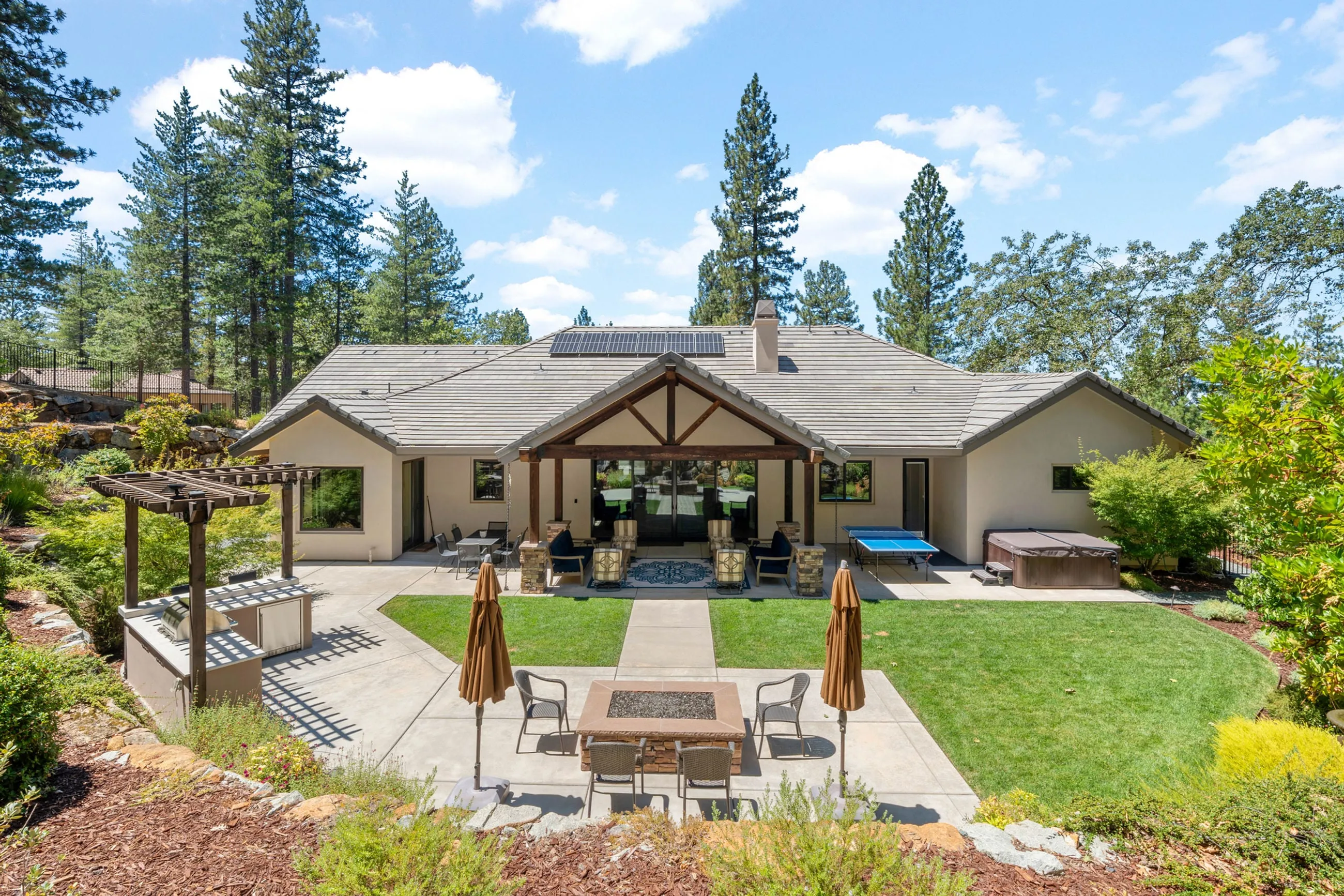 Rear yard overview with pavilion, hot tub, fire pit, pergola kitchen, and rooftop solar in Meadow Vista
