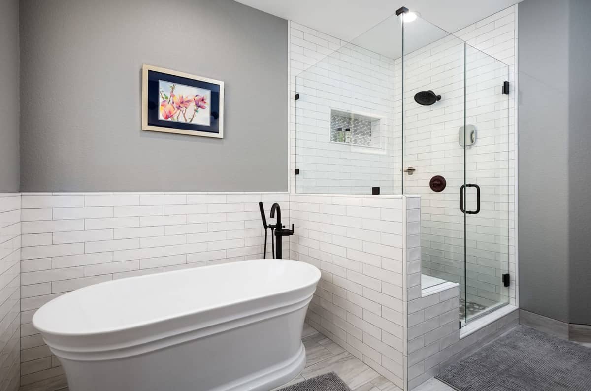 Bathroom with freestanding soaking tub, white subway tile, and glass-enclosed walk-in shower