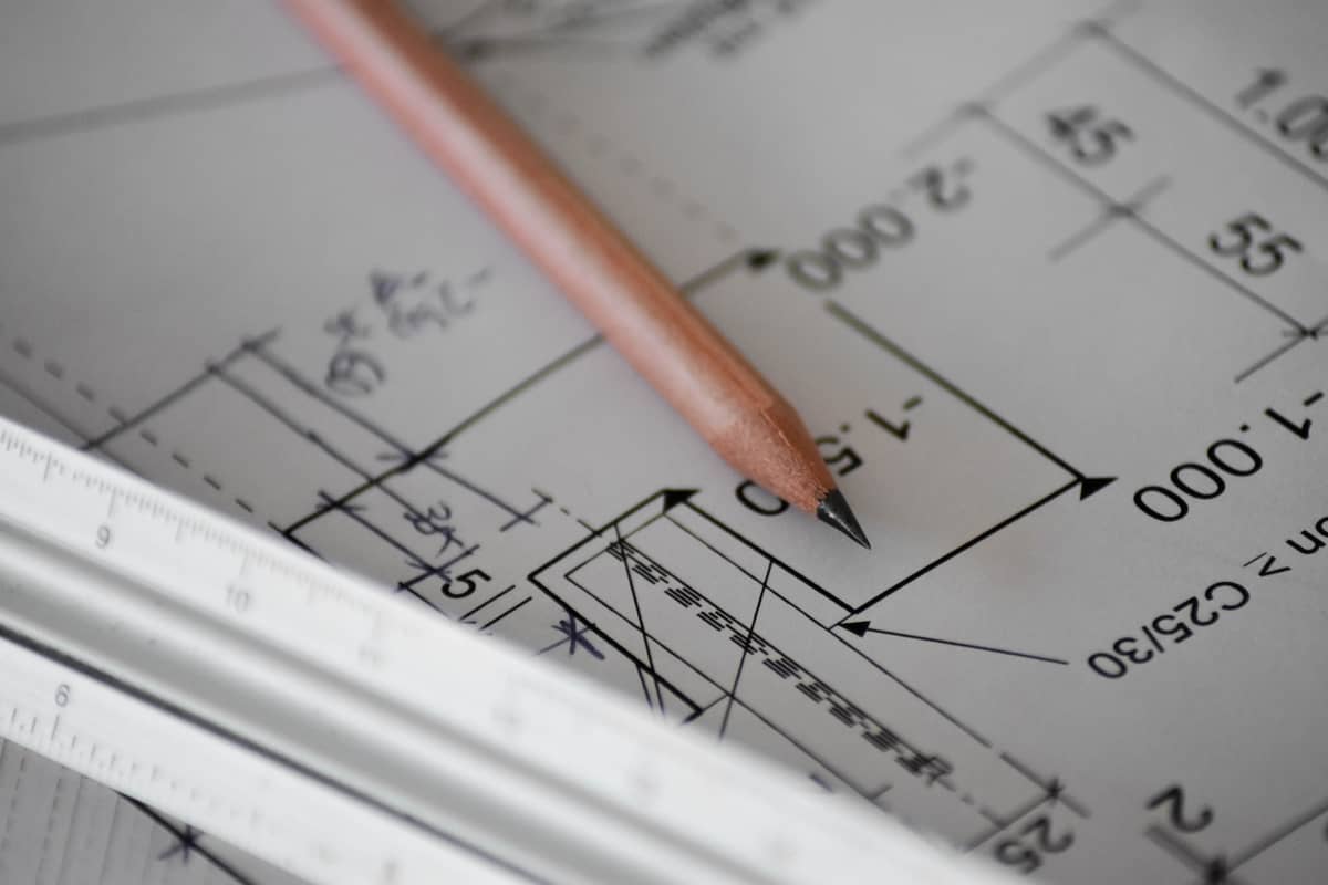 Sharpened pencil and ruler lying on an architectural drawing with dimension markings